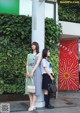 Two young women standing next to each other in front of a building.