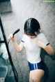 A woman standing in a shower holding a shower head.