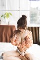 A woman sitting on top of a bed in a room.